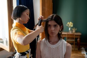 hairdresser straightening clients hair